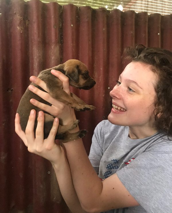 Abby cradling a small puppy.